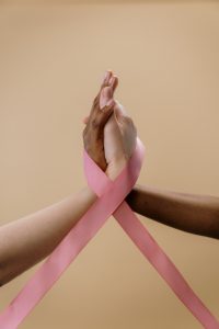 Holding hands inside pink cancer ribbon